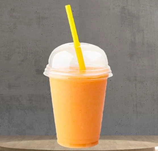Orange smoothie in a clear plastic cup with a yellow straw on a textured background.