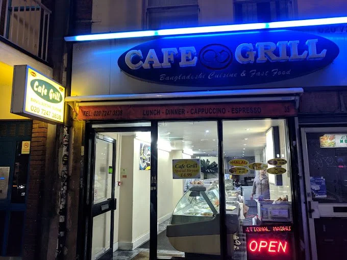 Exterior of Cafe Grill, a restaurant offering Bangladeshi cuisine and fast food, with a neon open sign.