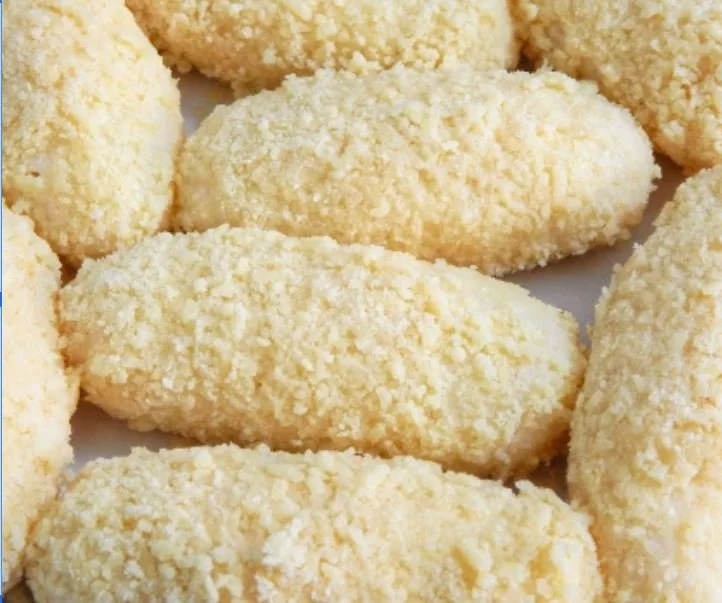 Close-up of breaded food items, likely croquettes or cutlets, on a plate.