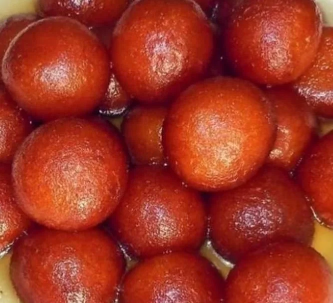 Close-up of gulab jamun, a popular Indian sweet, soaked in syrup.