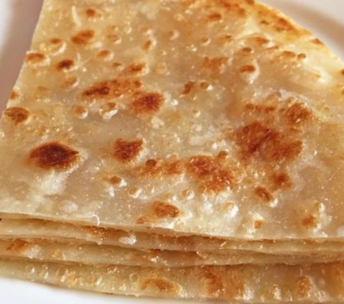 Stack of golden-brown flatbreads on a plate