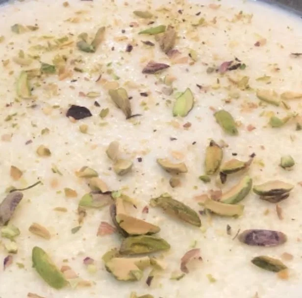 Close-up of rice pudding garnished with chopped pistachios.