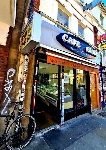 Exterior of a cafe grill with open door and bicycle parked outside