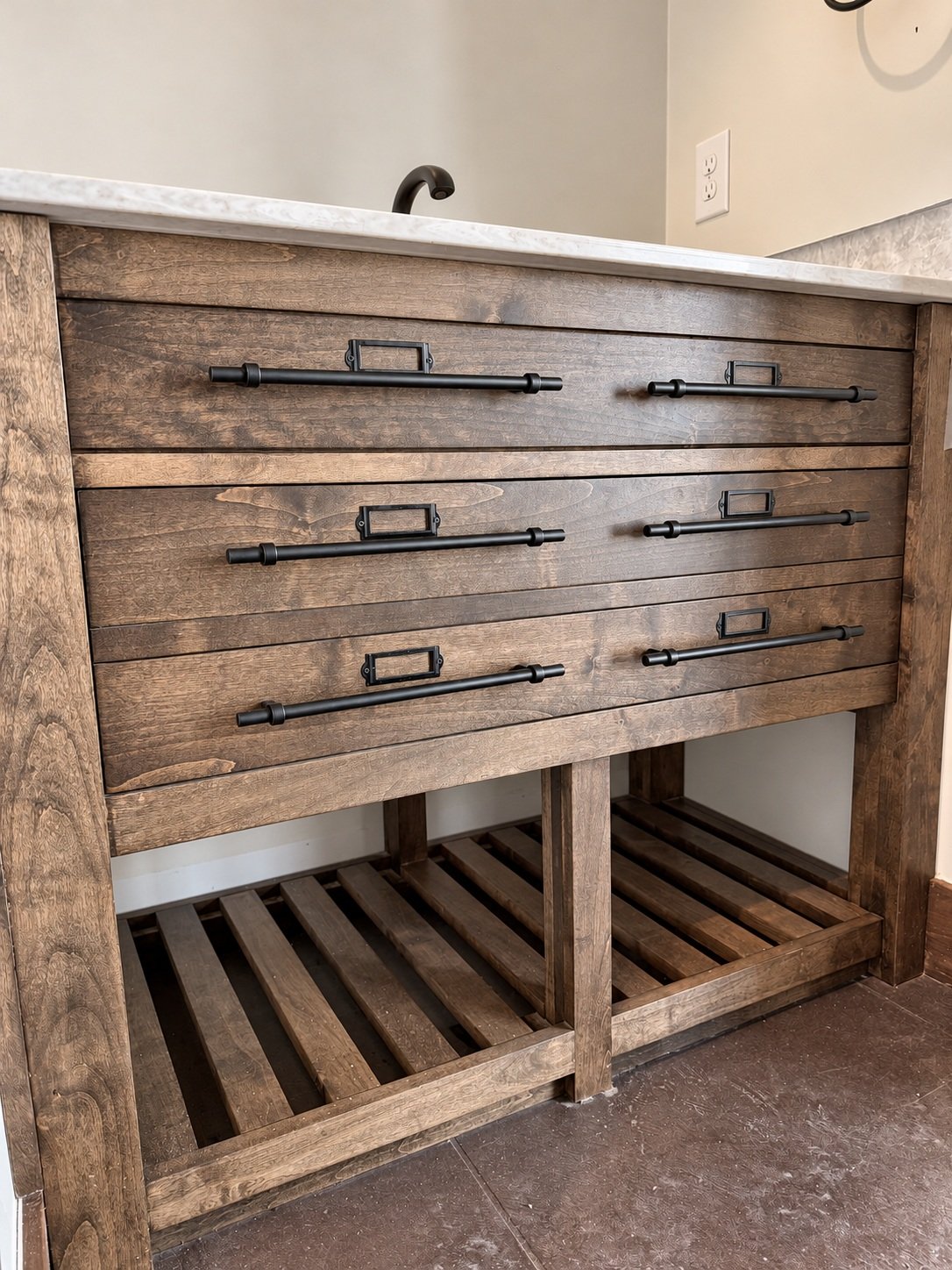 Close-up of wood vanity drawers with black bar pulls, label holders, visible wood grain, and open slatted shelves.