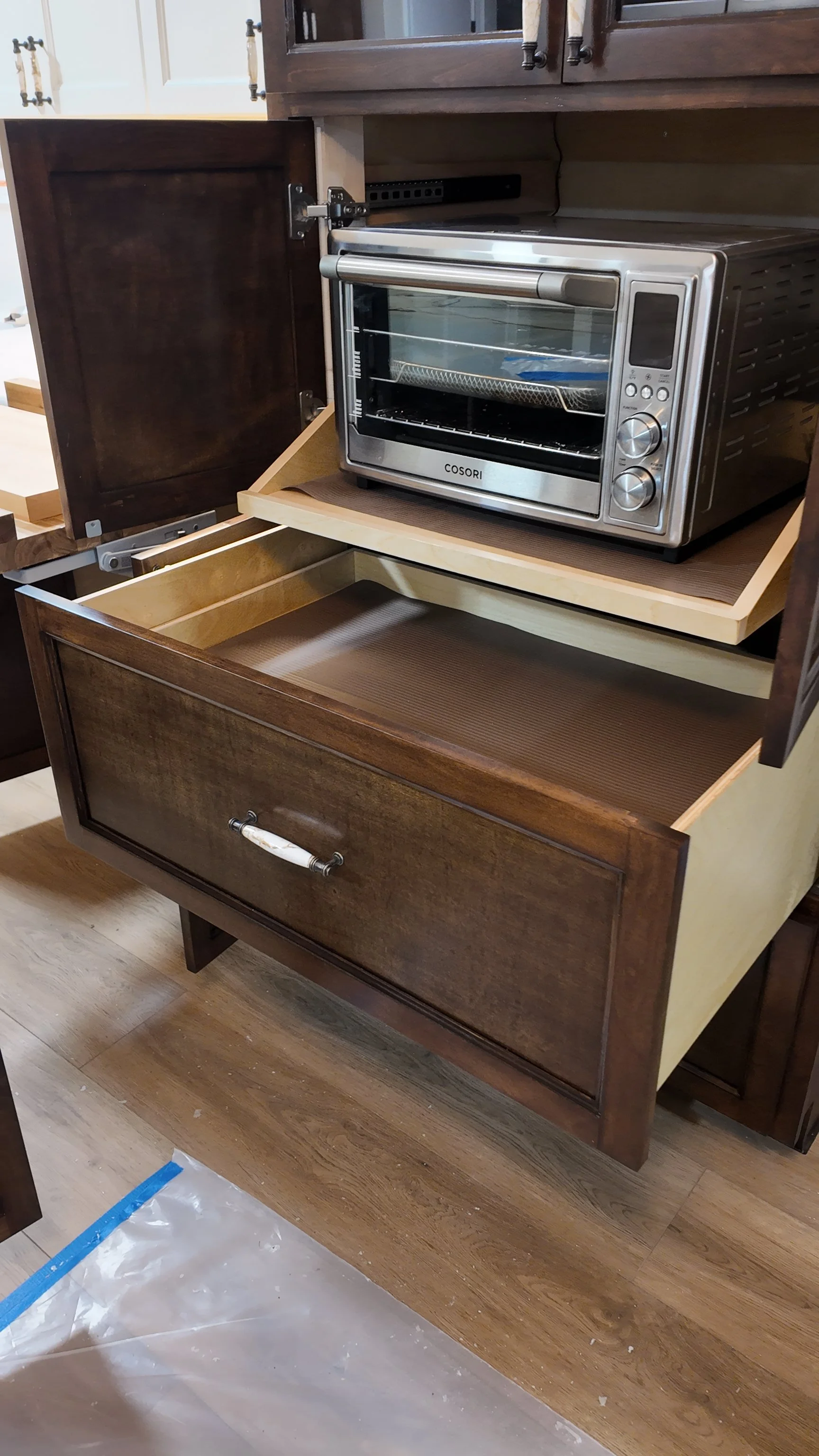 Open kitchen cabinet with a built-in toaster oven inside.