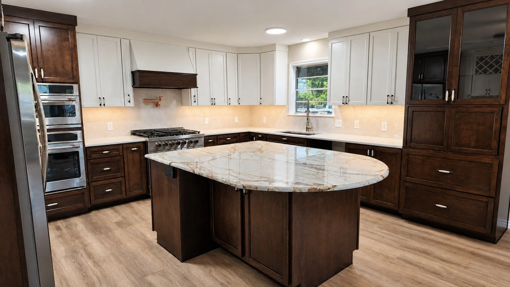 Two Tone custom kitchen with rich wood cabinetry, light upper cabinets, and a pale stone island.