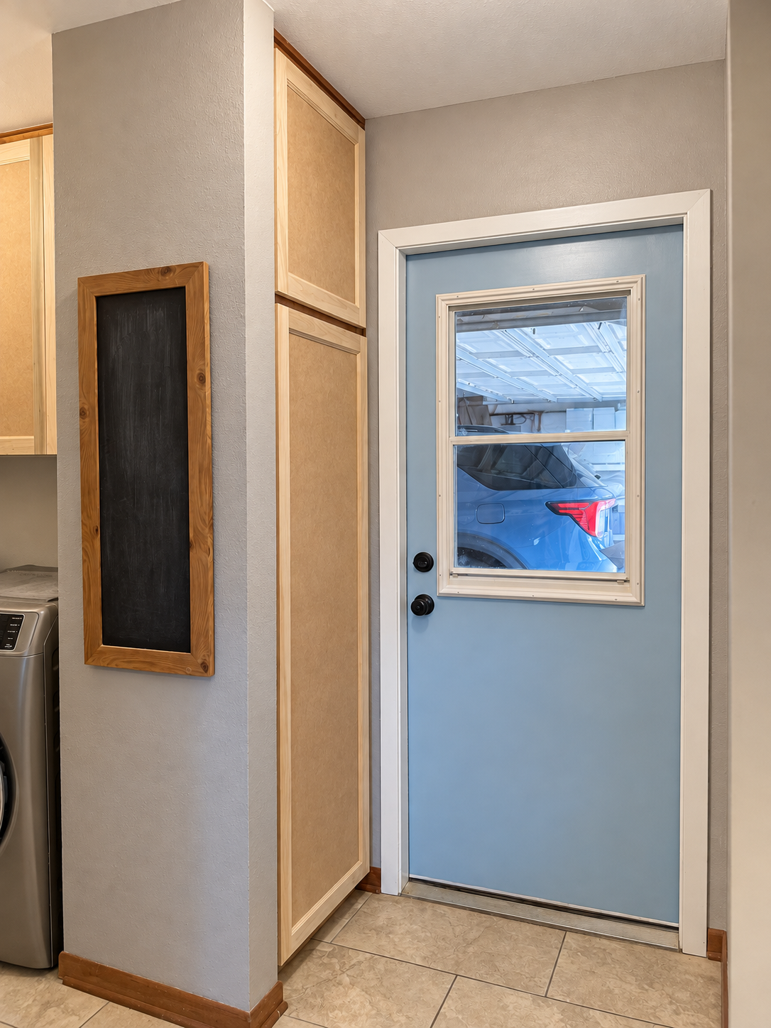 Refaced tall storage beside the doorway, with unfinished cabinet fronts.