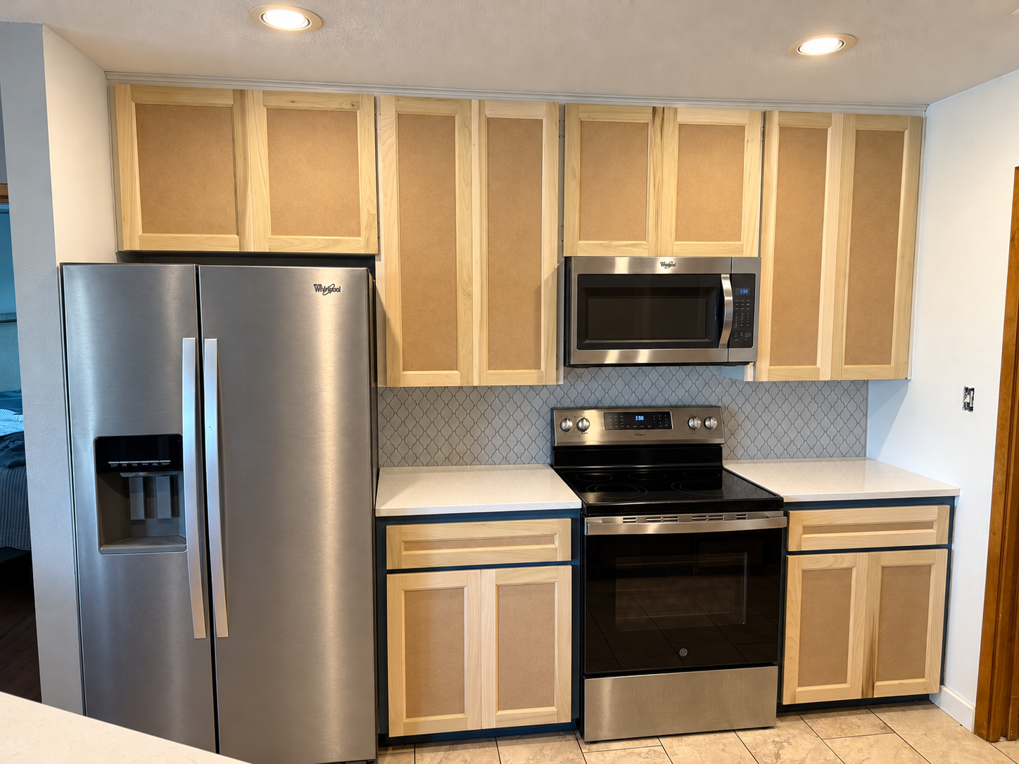Kitchen cabinet refacing in progress, with new natural wood-framed doors and drawer fronts.