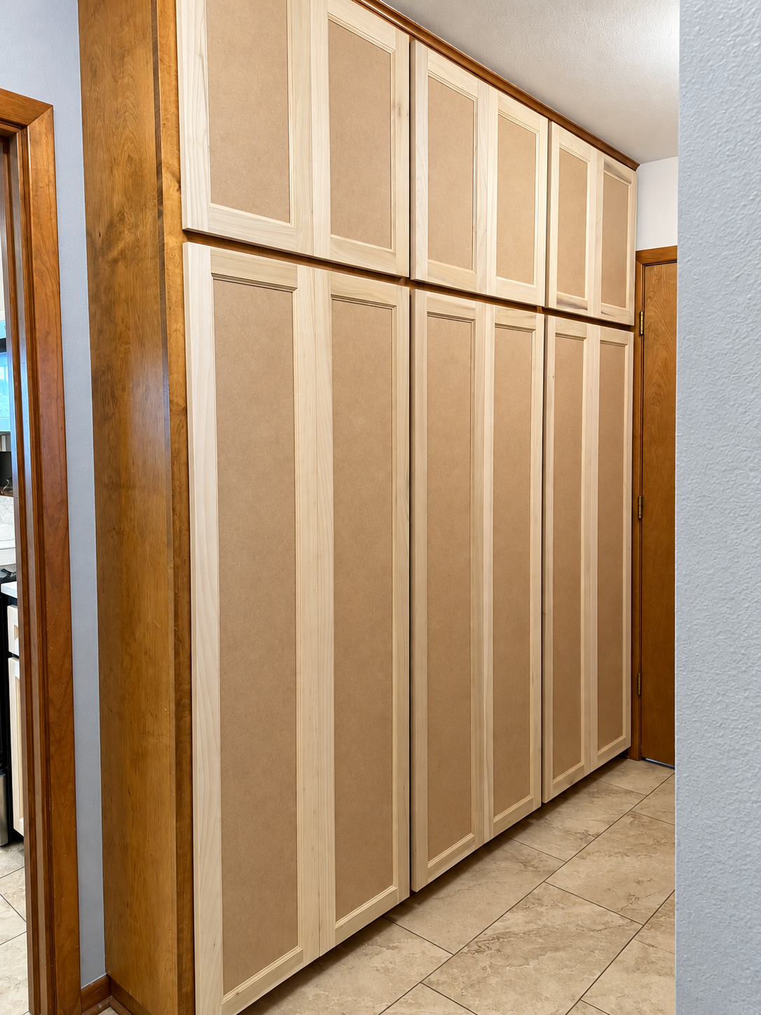 Tall storage cabinetry with new clean-lined doors, refacing in progress.