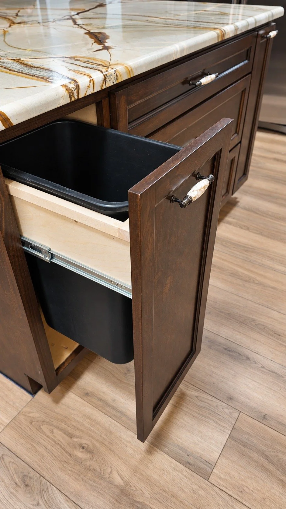 Integrated waste storage within the island cabinetry.