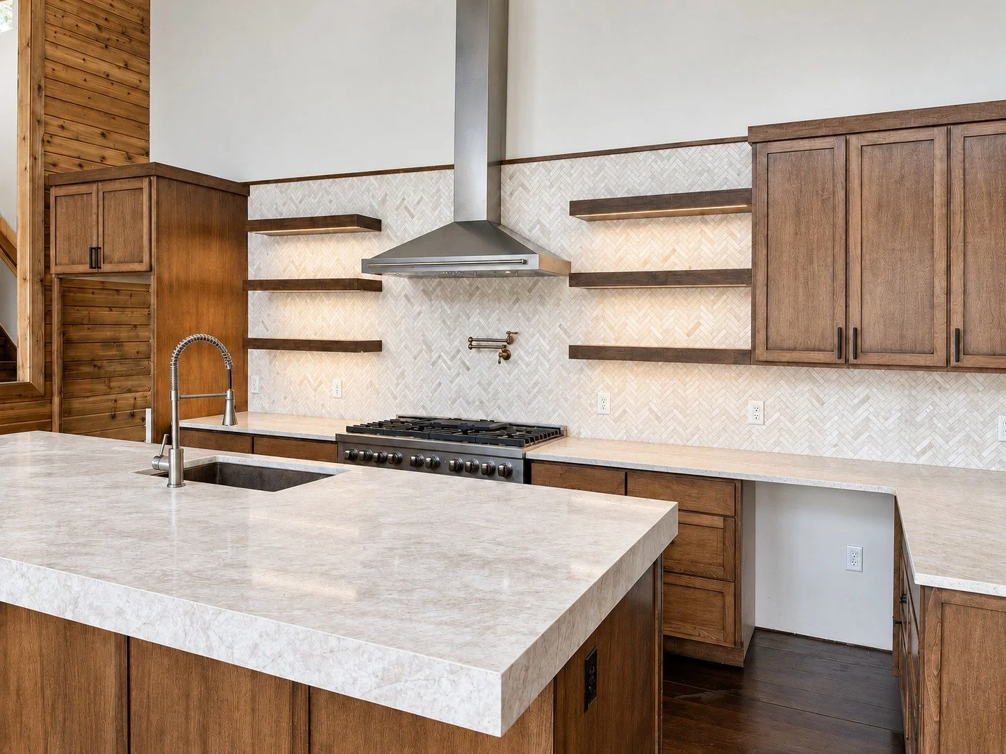 M5 Ranch custom wood kitchen cabinetry, floating shelves, and a generous pale stone island.