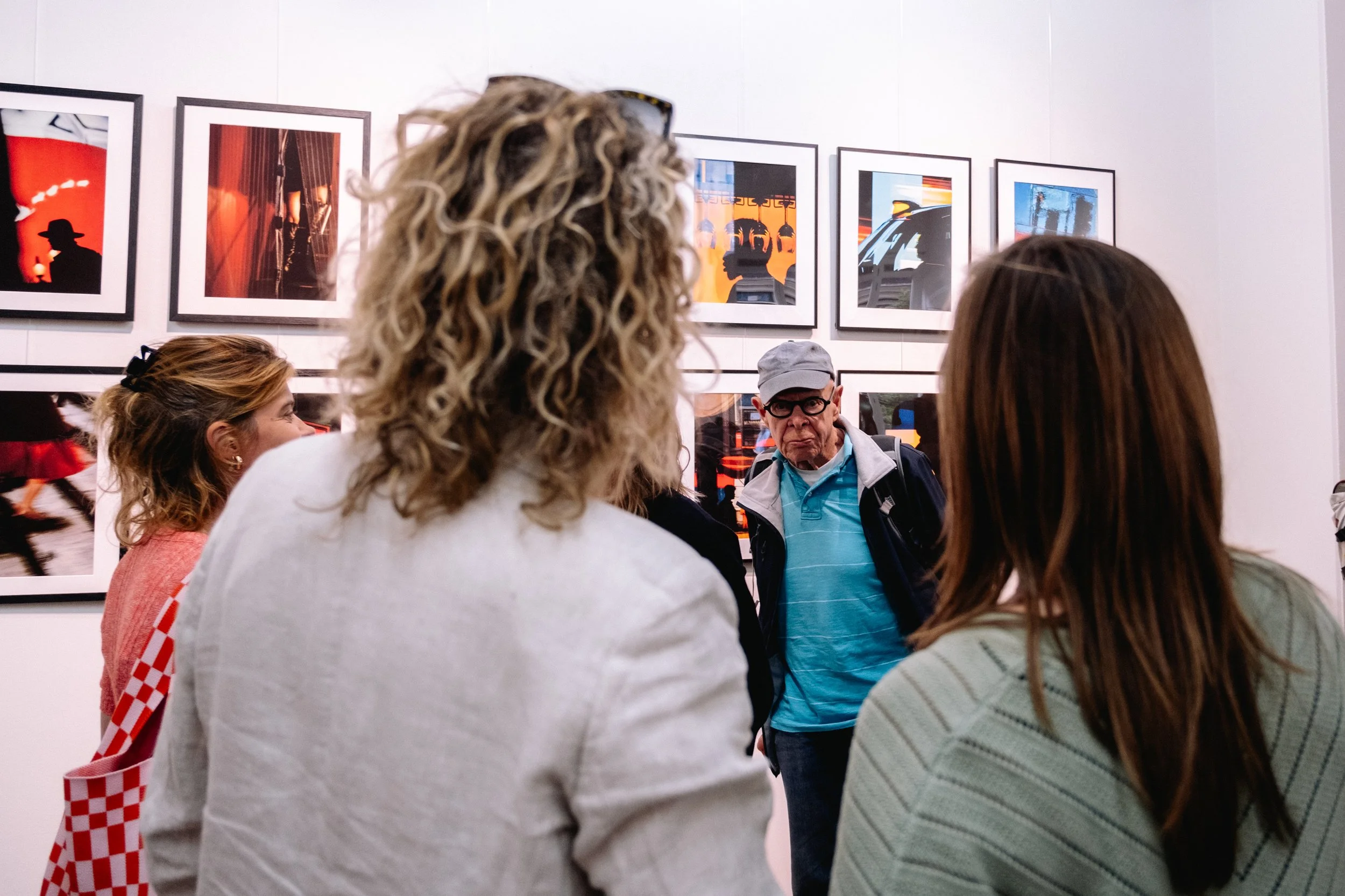 A group of people looking at framed artwork in an art gallery