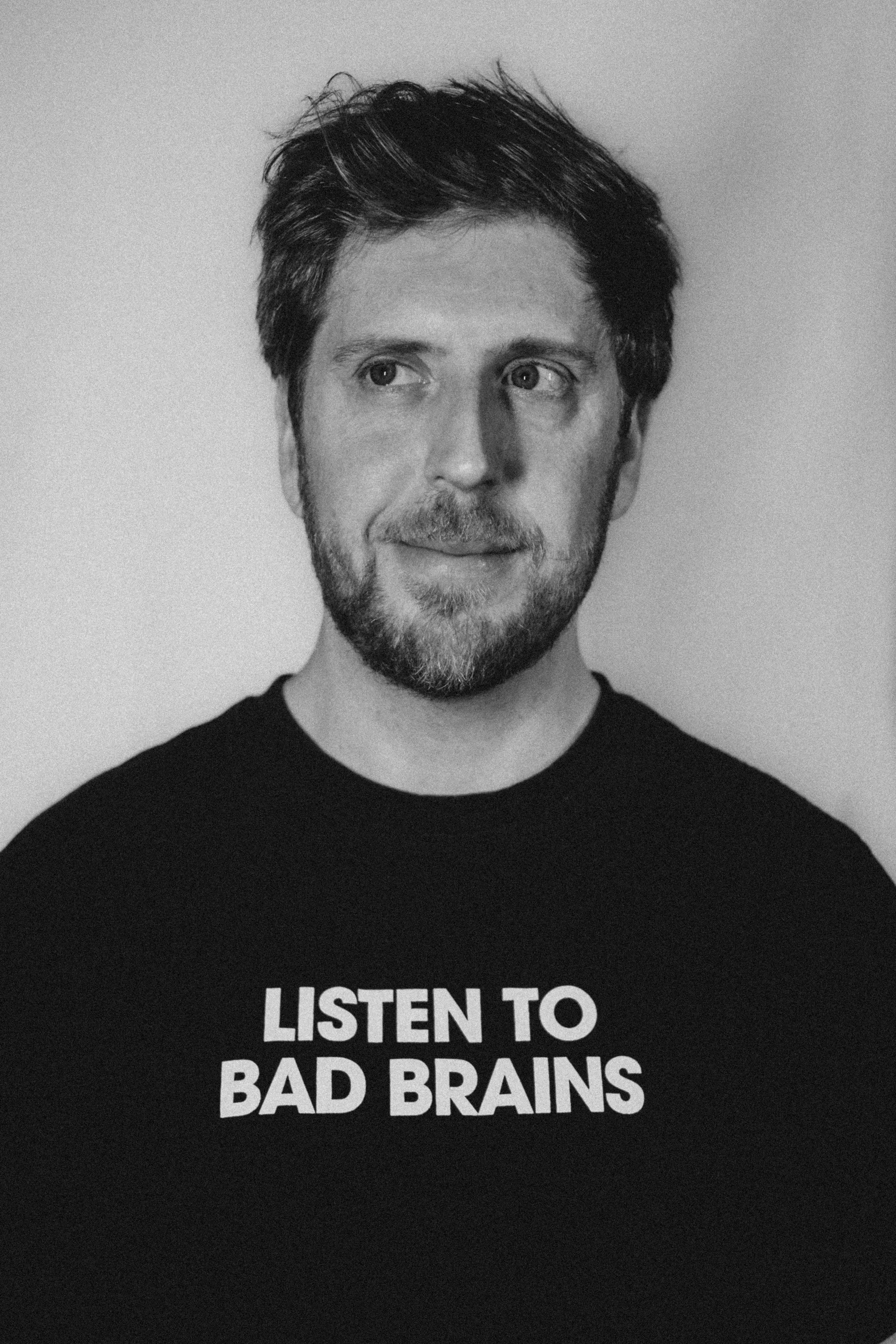 Photo of Sébastien Jean , a street photographer, wearing a black T-shirt with the message "LISTEN TO BAD BRAINS" printed on it.