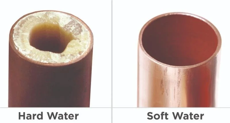 Comparison of a PVC pipe filled with hard water and another with soft water, showing the difference in mineral buildup.