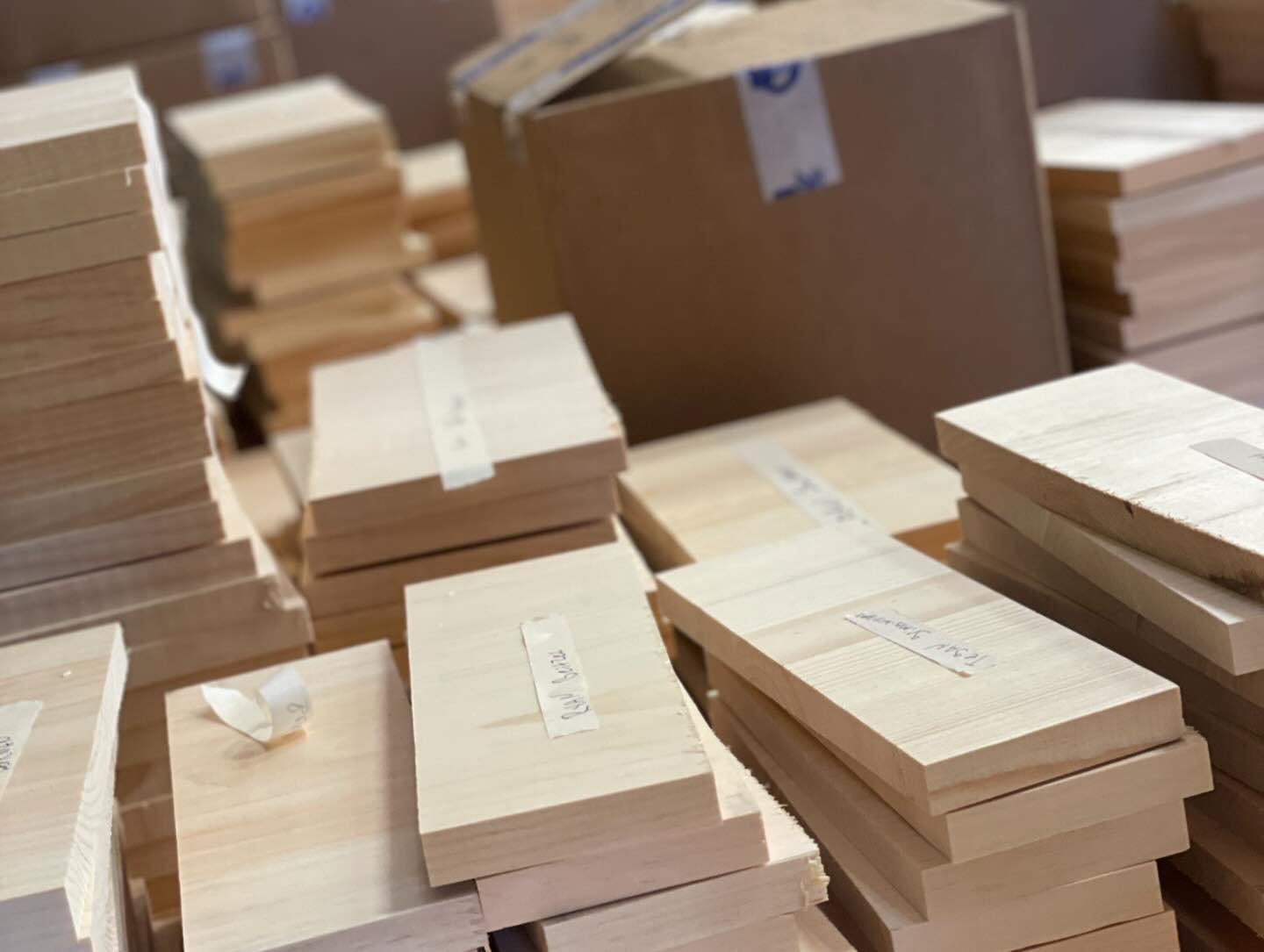 Piles of wooden boards stacked in a workshop or storage area.