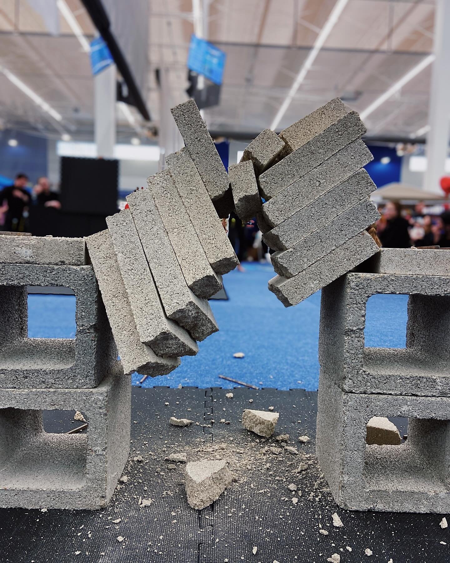 Concrete blocks broken in a martial arts demonstration on blue mat