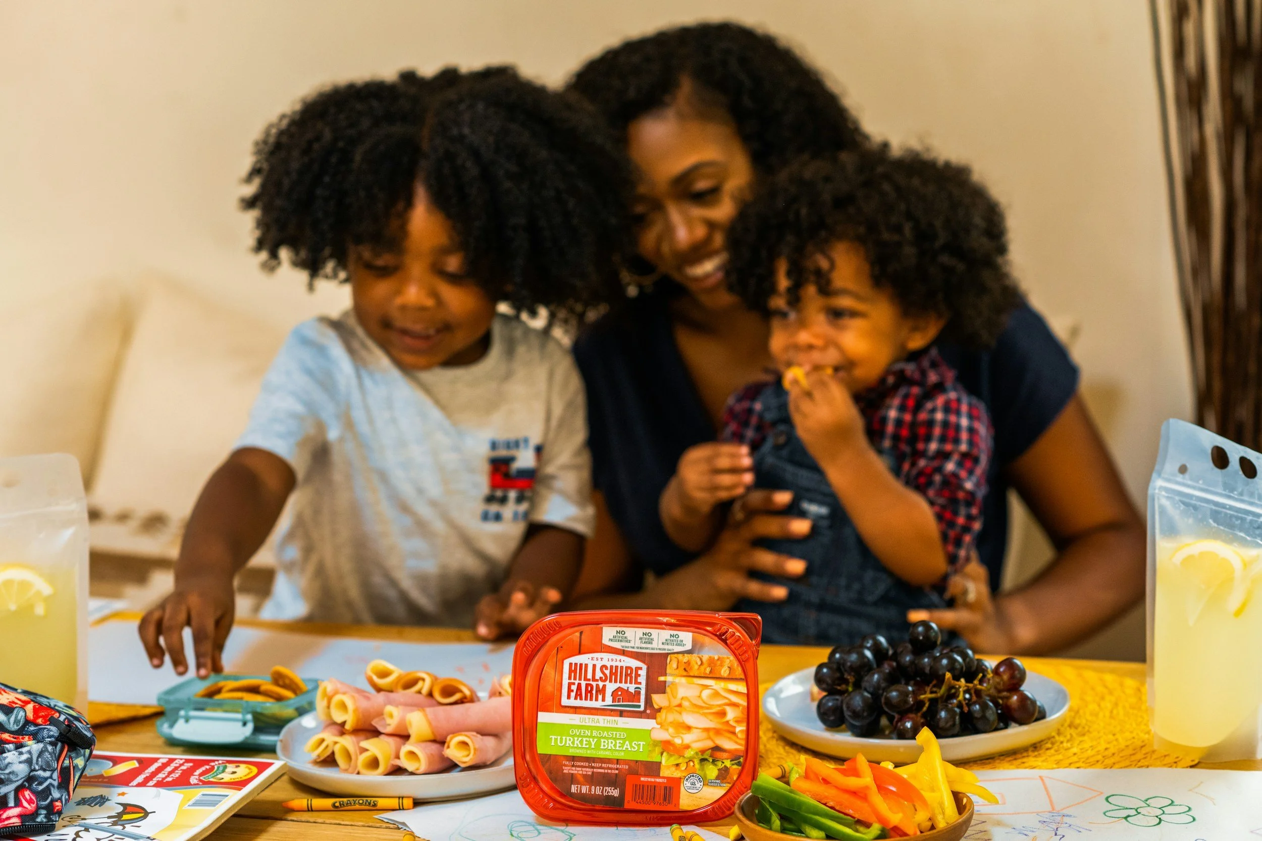 Family enjoying snacks with Hillshire Farm turkey, grapes, and lemonade.