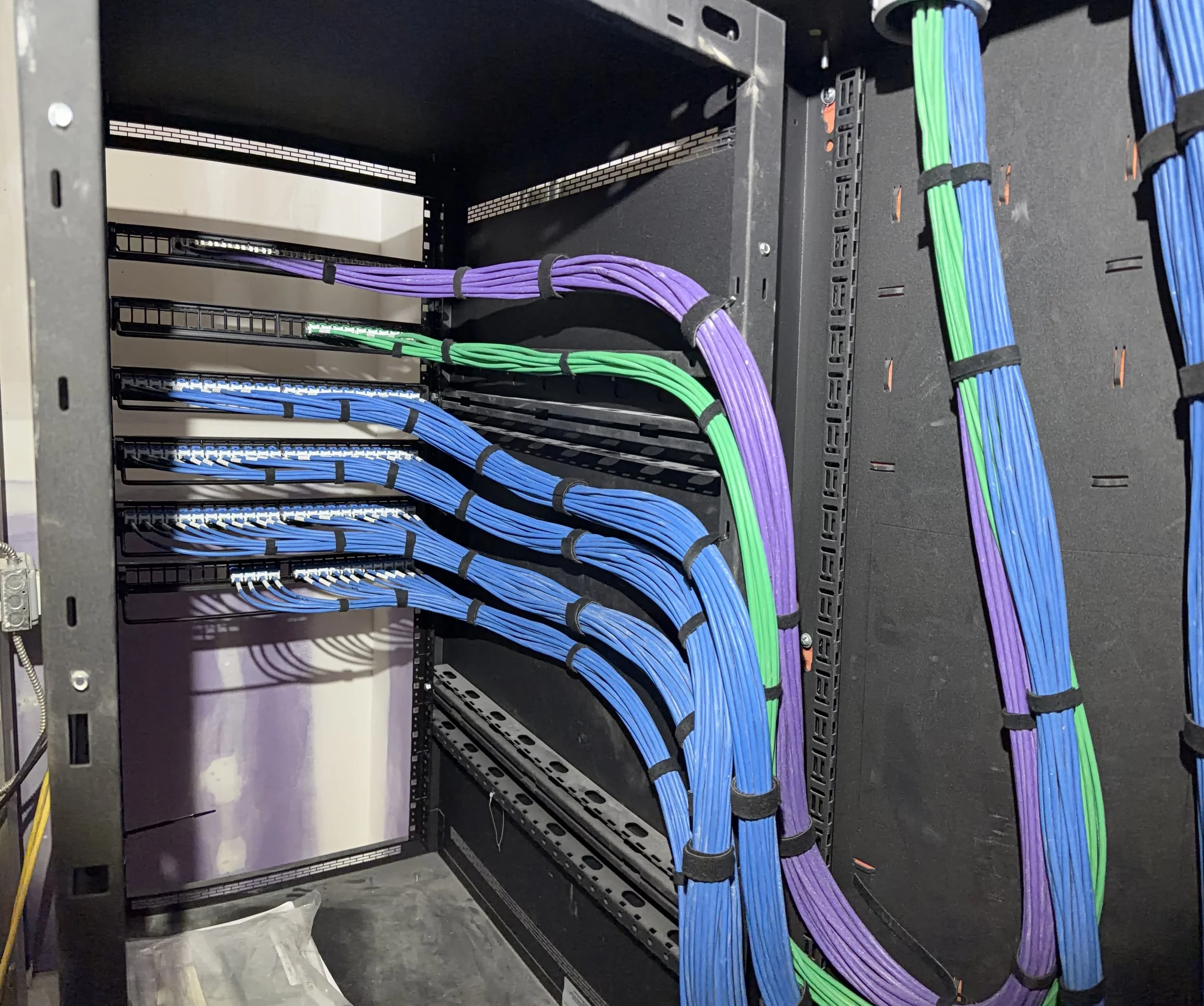 Colorful network cables arranged in a server rack with purple, green, and blue cables.
Michigan structured cabling