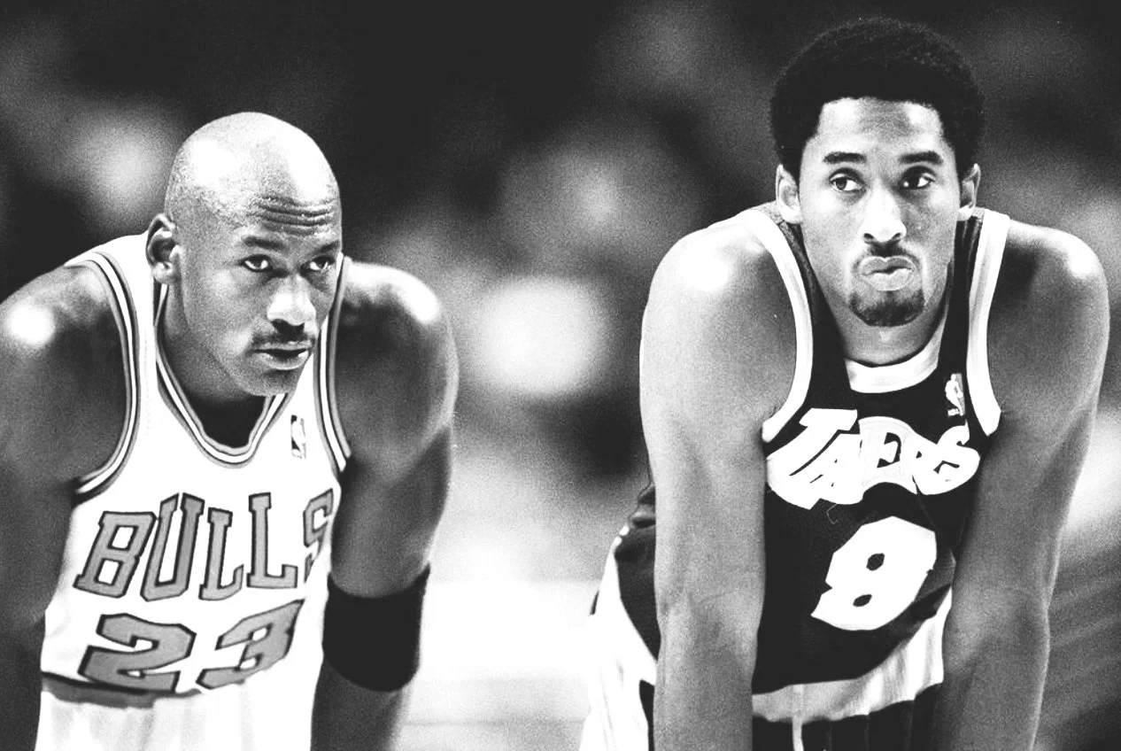 Black and white photograph of two professional basketball players wearing jerseys, one from the Chicago Bulls and the other from the Los Angeles Lakers, during a game.