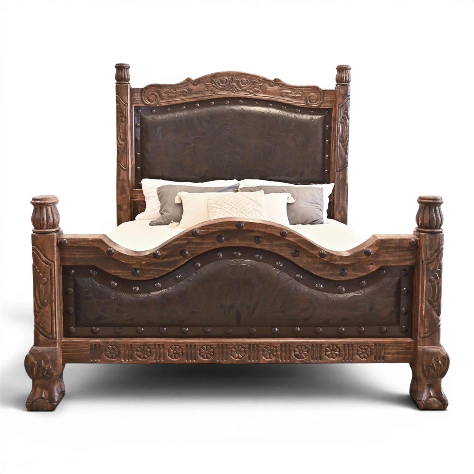 Handmade Red Lodge tooled leather bed with arched headboard, hand-carved wood, iron trim, and decorative clavos.