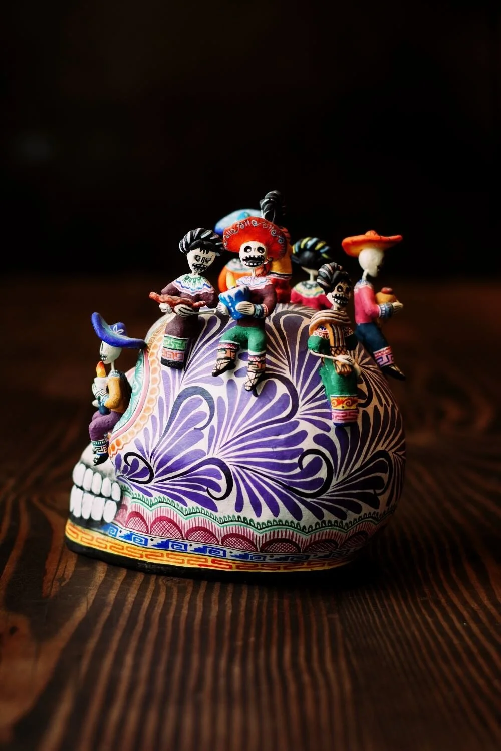 Shop a handmade Montesinos skull with Catrinas from Mexico. Colorful clay folk art with intricate detail, perfect for unique decor displays.