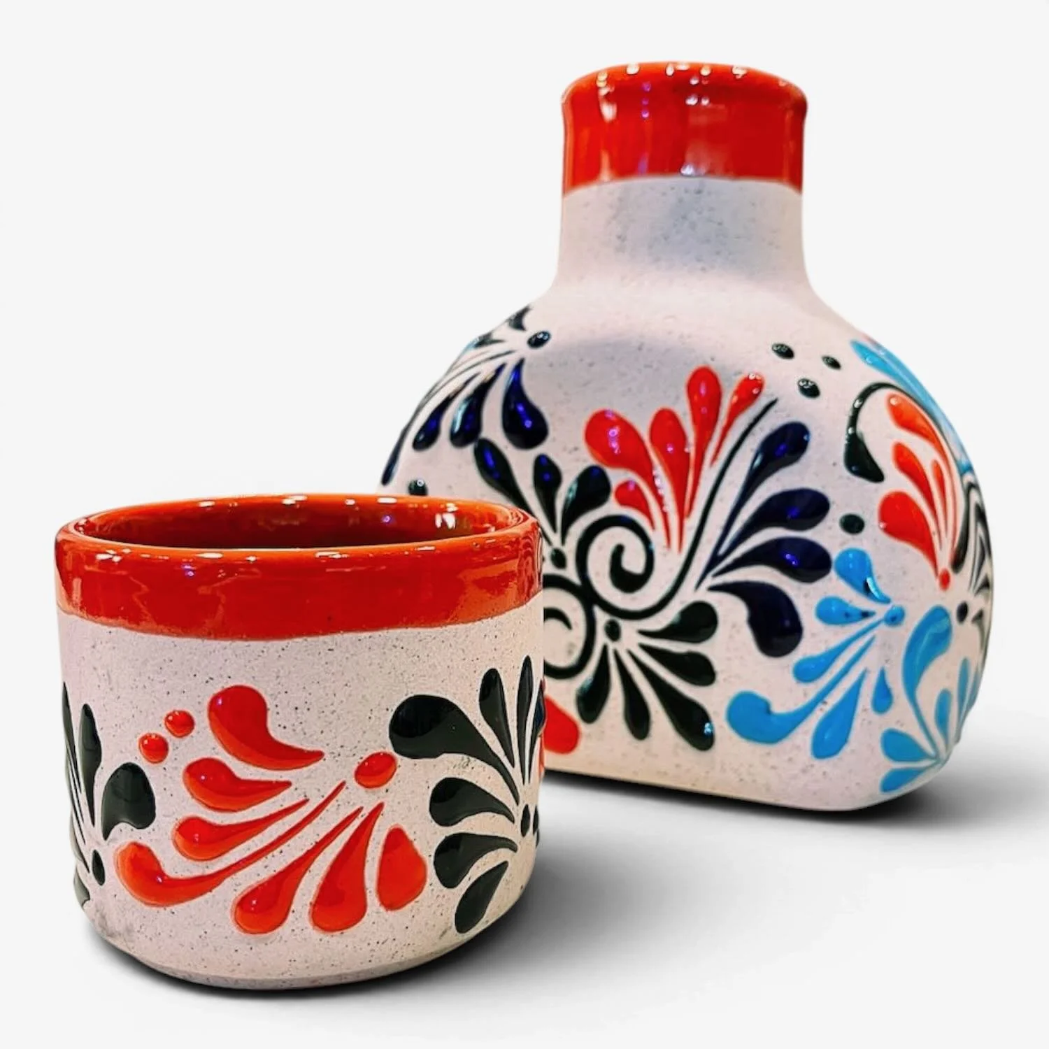 Handmade Mexican stone tequila bottle and matching shot cup with colorful hand-painted design