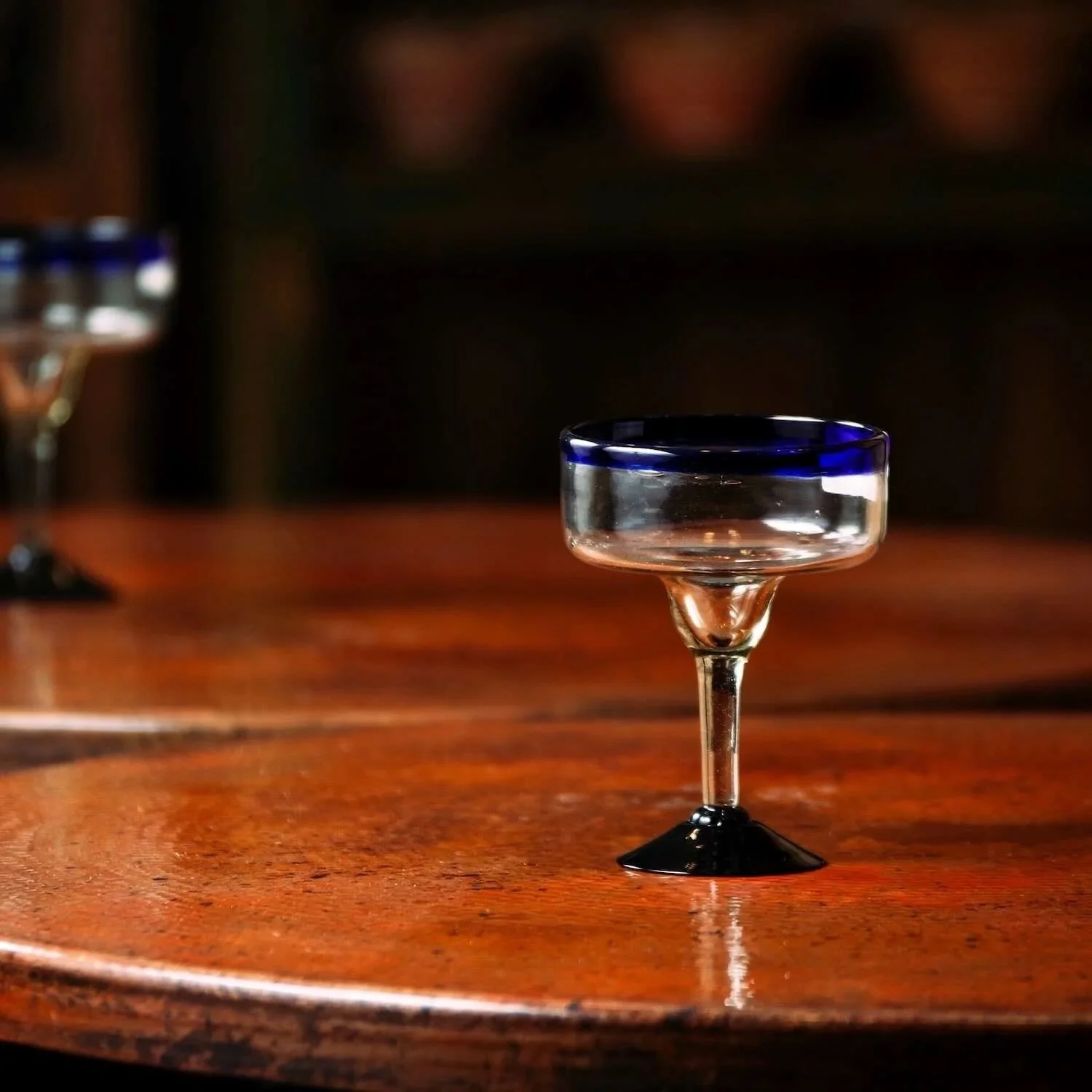 Set of two handmade Mexican handblown margarita glasses with traditional cobalt blue rims.