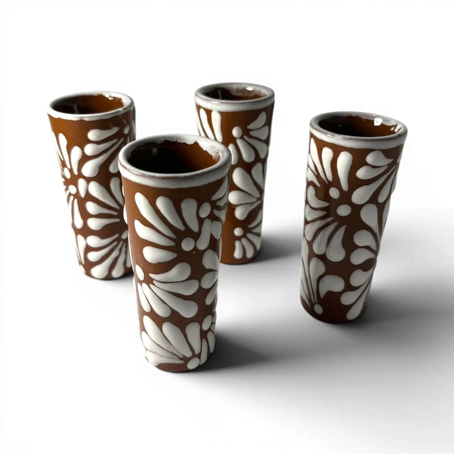 Set of six handmade Mexican Tequila Terracota shot glasses with white textured floral design.