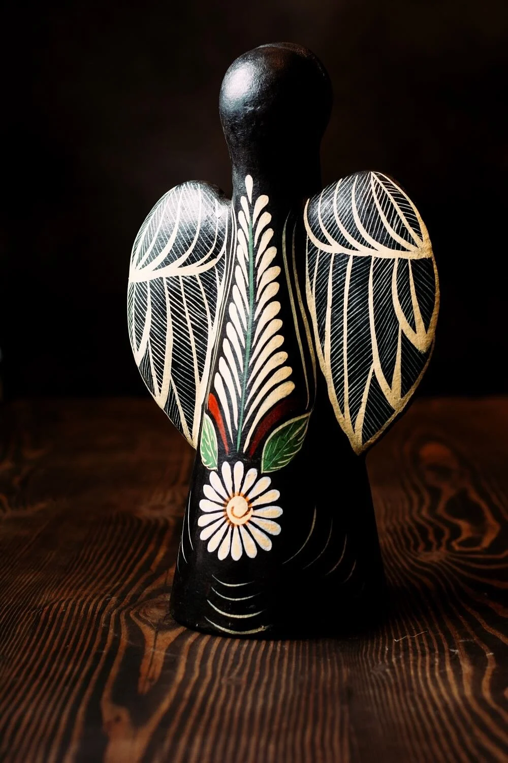 Shop a handmade clay angel luminaria from Mexico. Black finish with colorful floral design and cutouts for warm ambient candle lighting.