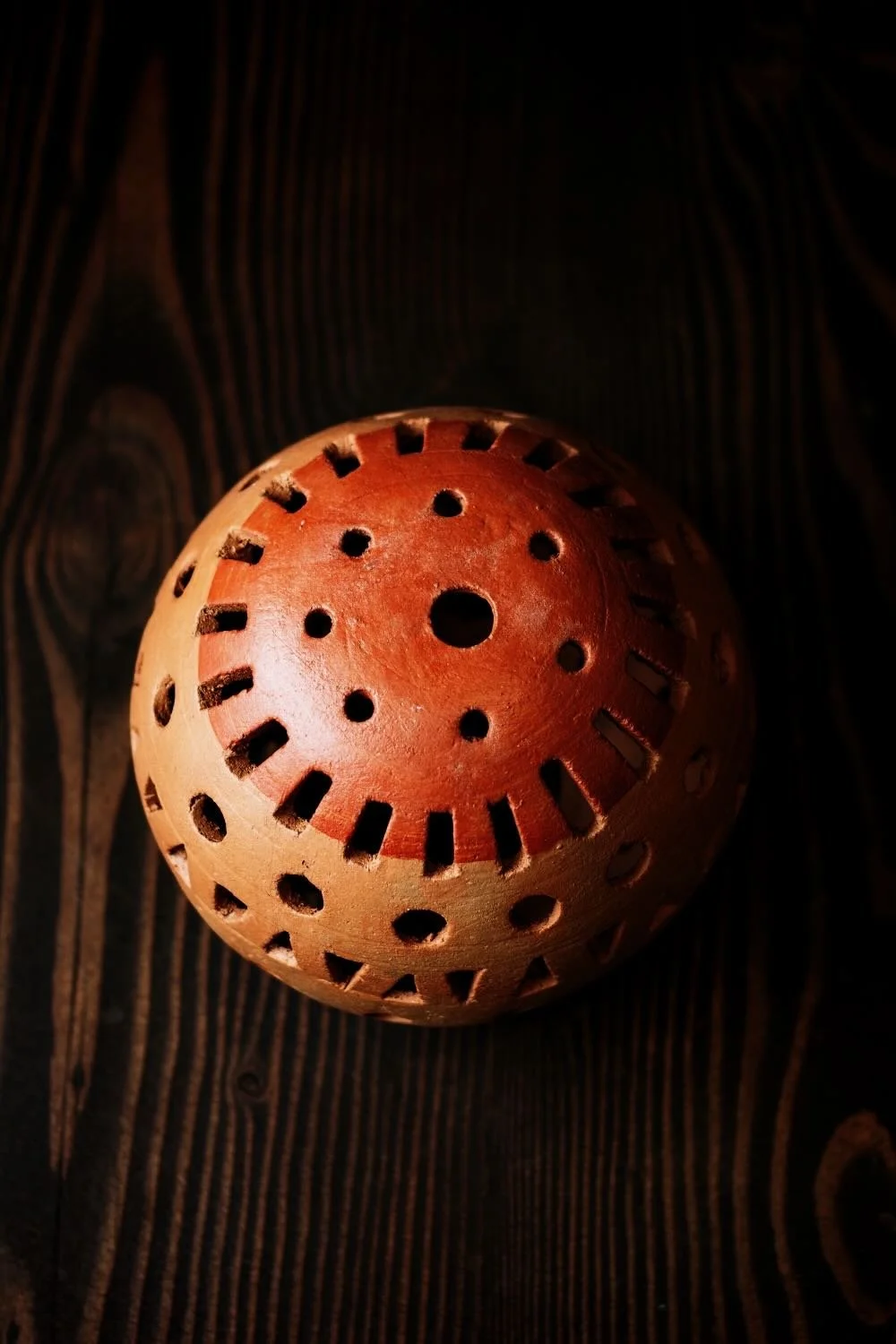 Shop a handmade clay sphere luminaria from Oaxaca, Mexico. Unique cutout design creates warm ambient candlelight for rustic decor.