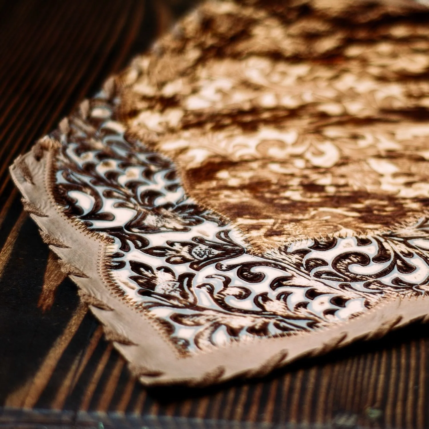 Handmade Brazilian cowhide table runner with tooled leather.