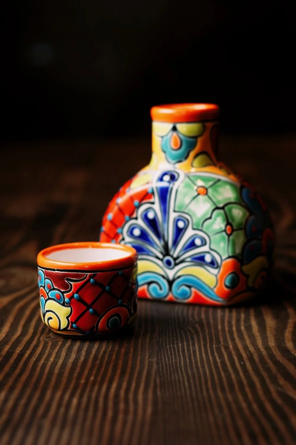 Shop a handmade Talavera tequila bottle with cup lid from Mexico. Colorful, lead-free artisan barware perfect for serving and display.