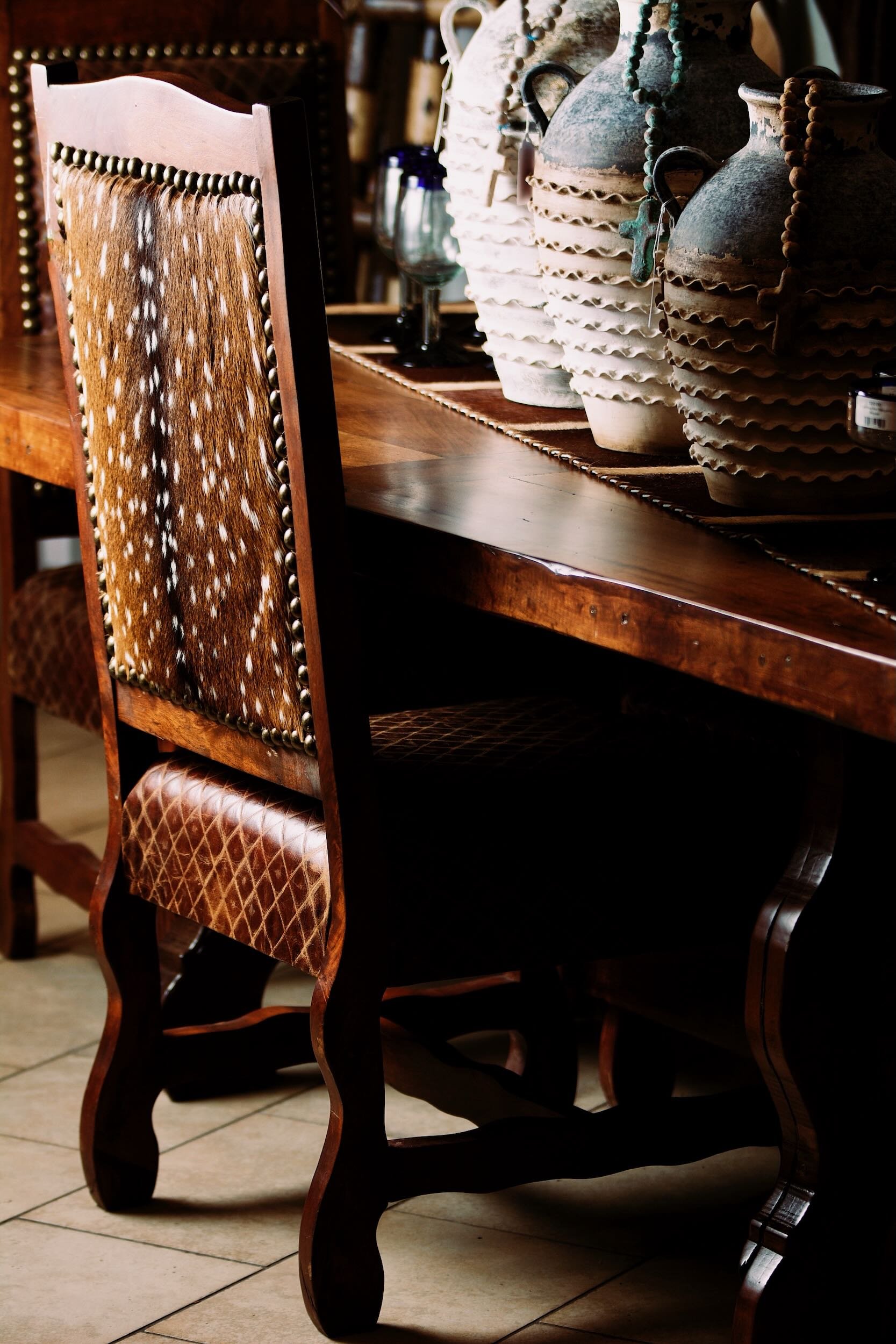 Handmade dining table and chairs with a Talavera clay vases on top from Mexico.