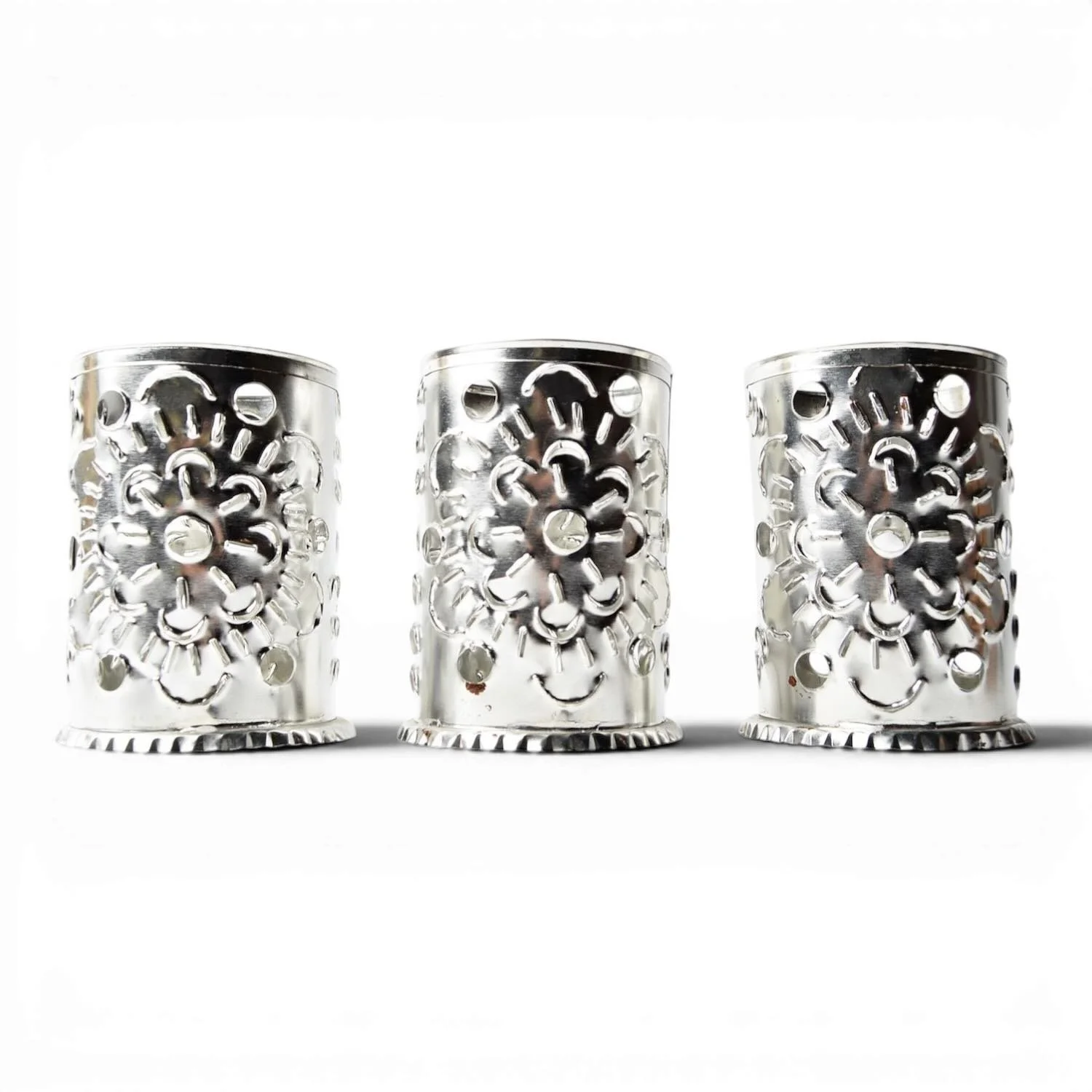 Handmade Luminarias Plata candle lanterns with punched tin silver finish casting elegant ambient light.