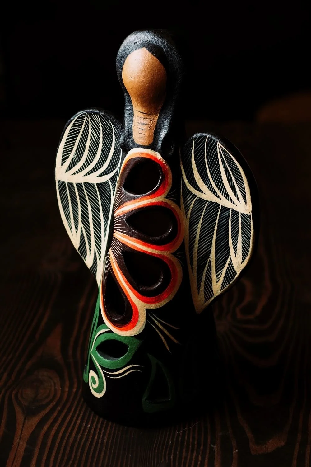 Shop a handmade clay angel luminaria from Mexico. Black finish with colorful floral design and cutouts for warm ambient candle lighting.