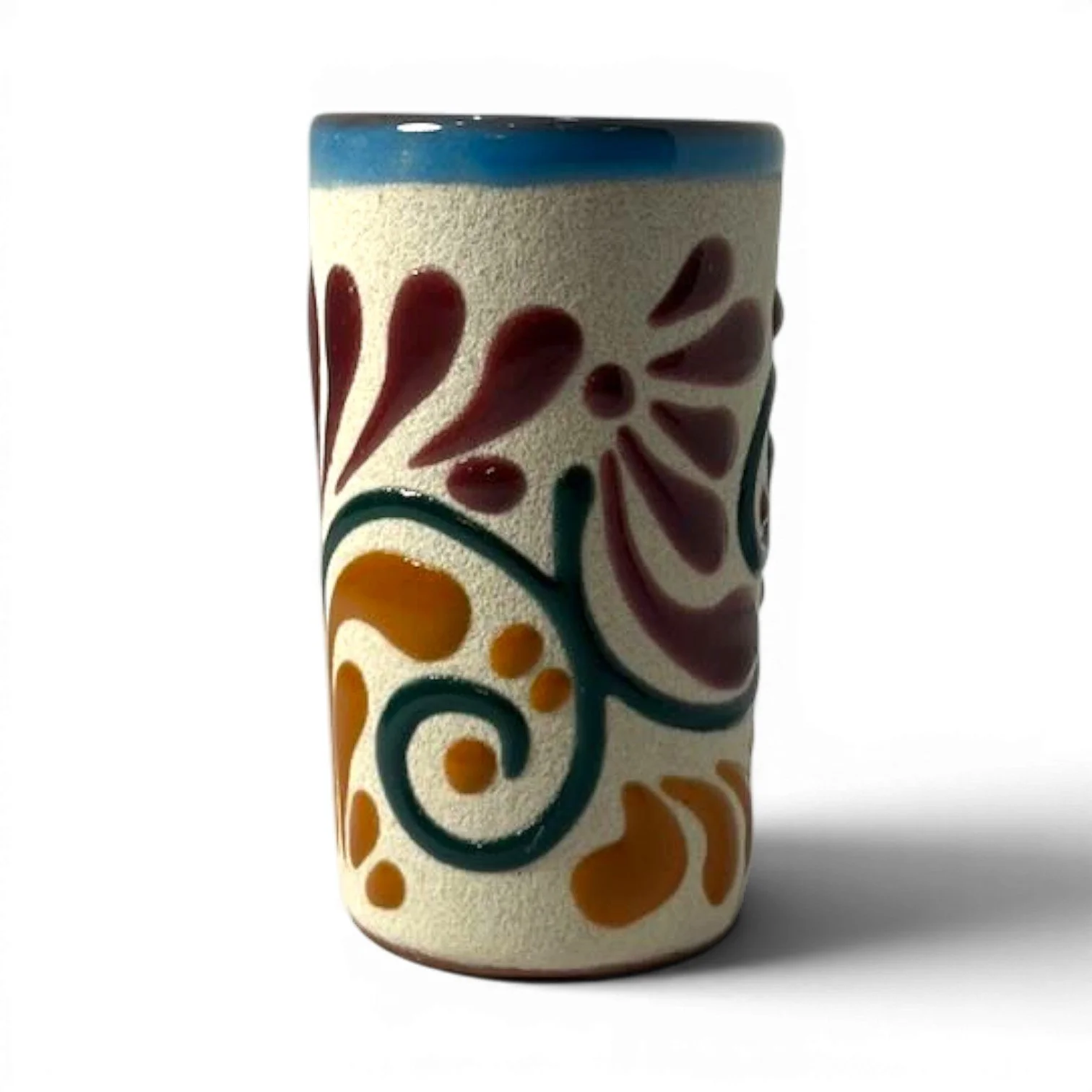 Handmade Mexican stone tequila shot cups with vibrant Talavera design and glazed interior.