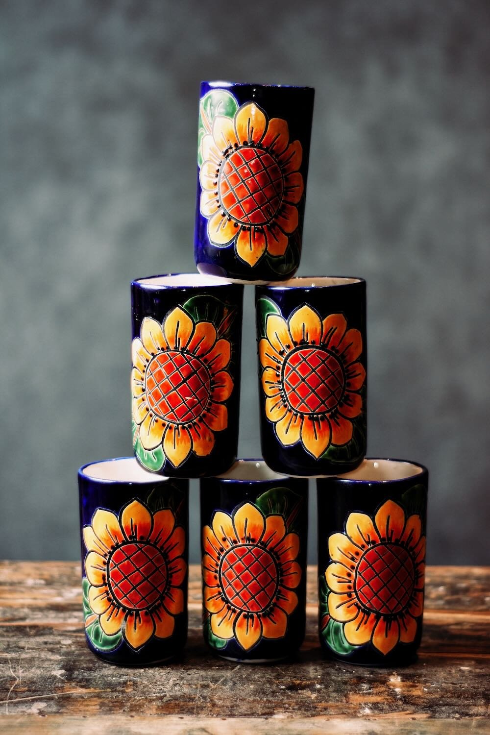 Talavera Sunflower Pitcher & Cup Set. Hand-painted Talavera set featuring a cobalt blue pitcher and matching cups with a vibrant sunflower design.
