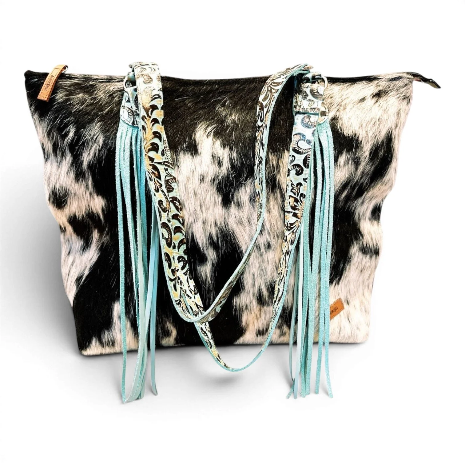 Handmade Brazilian Sheridan cowhide tote bag with black and white cowhide, black leather back, and turquoise fringe