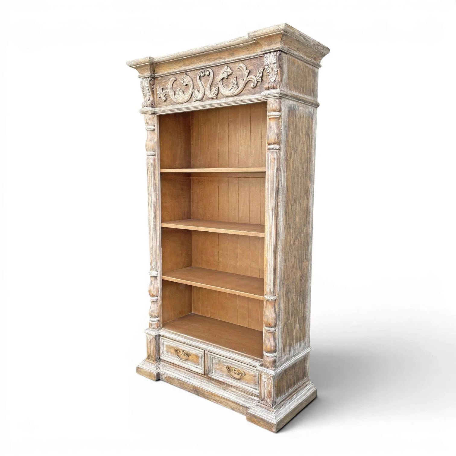 Yucca carved Peruvian bookcase with distressed wood finish, floral scrollwork top frieze, open shelving, and lower storage drawers.