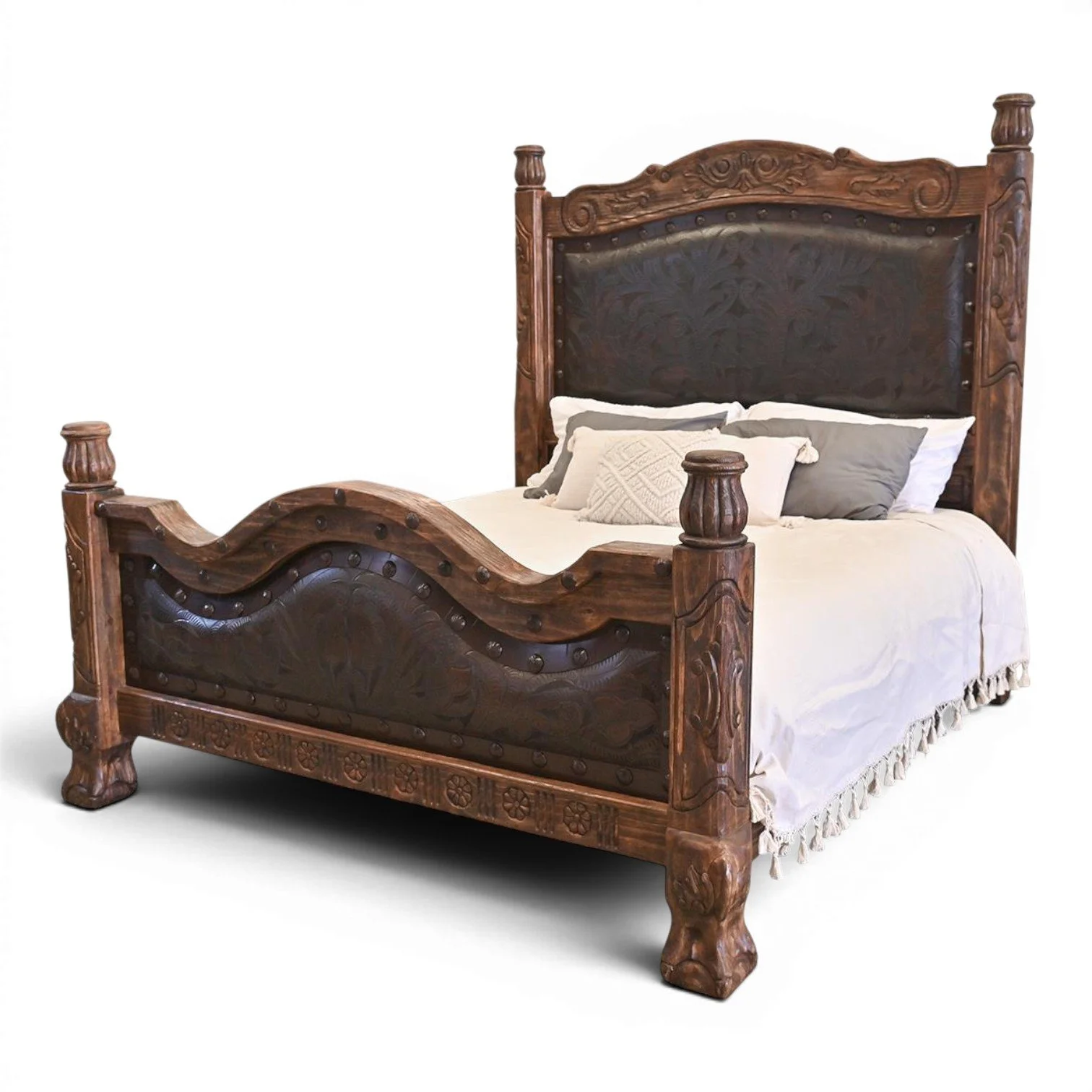 Handmade Red Lodge tooled leather bed with arched headboard, hand-carved wood, iron trim, and decorative clavos.
