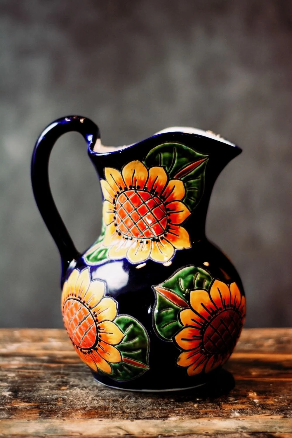 Talavera Sunflower Pitcher & Cup Set. Hand-painted Talavera set featuring a cobalt blue pitcher and matching cups with a vibrant sunflower design.