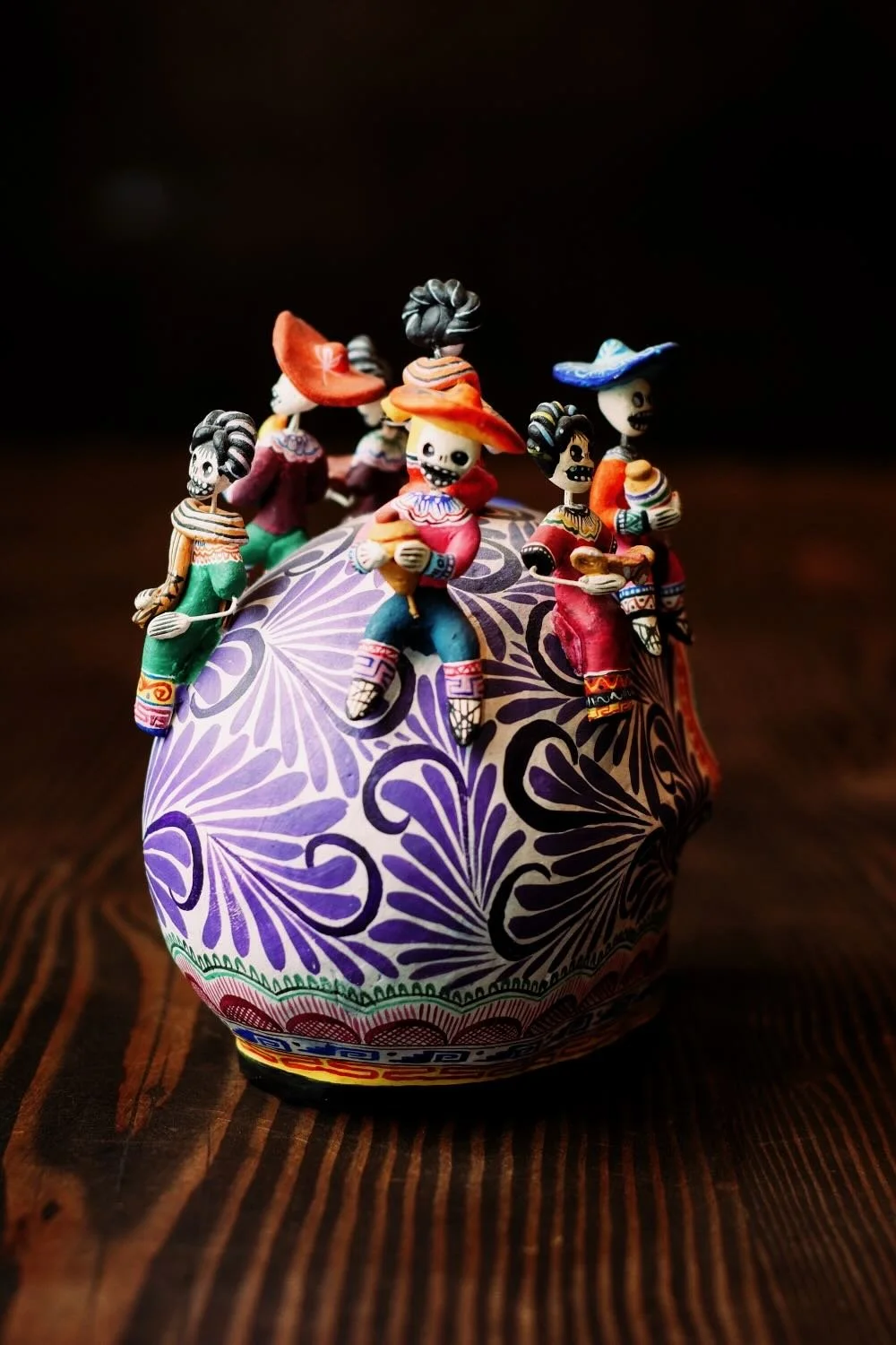 Shop a handmade Montesinos skull with Catrinas from Mexico. Colorful clay folk art with intricate detail, perfect for unique decor displays.