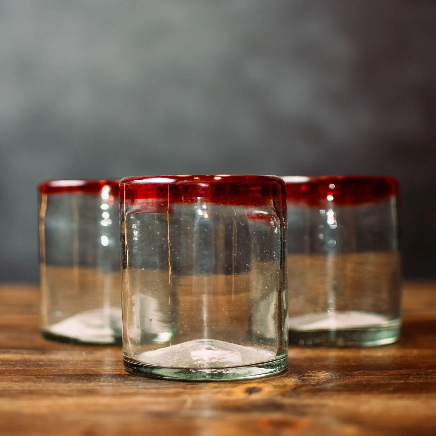 Handmade Mexican Cantina short glass with traditional red rim and handblown artisan craftsmanship.