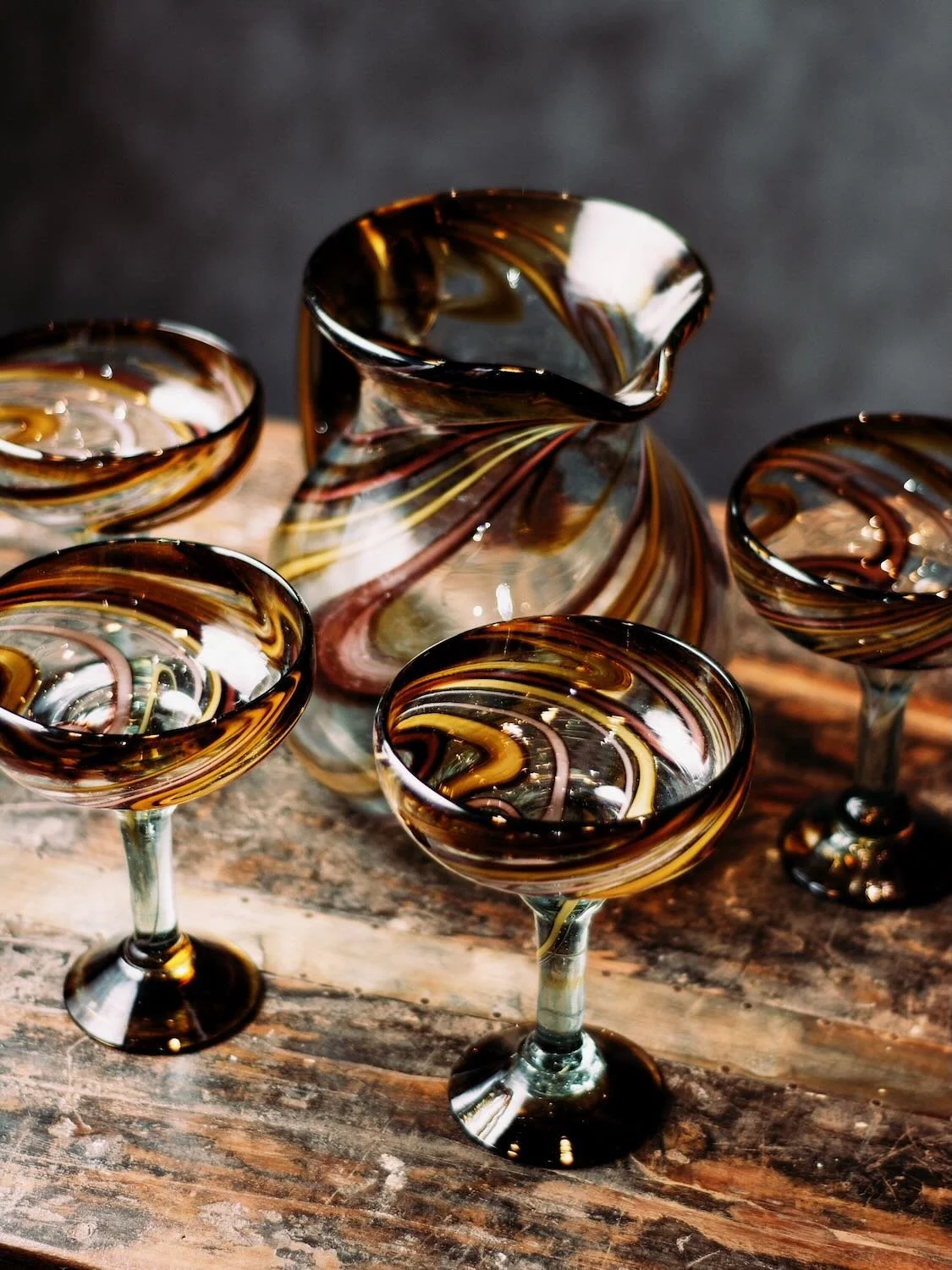 There is a distinct rhythm to a Mexican afternoon—a slow transition from the golden heat of the sun to the cool, purple shadows of the evening. Our newest arrival, the Oro y Morado Set, captures that exact moment in glass.

Handblown by master artisa