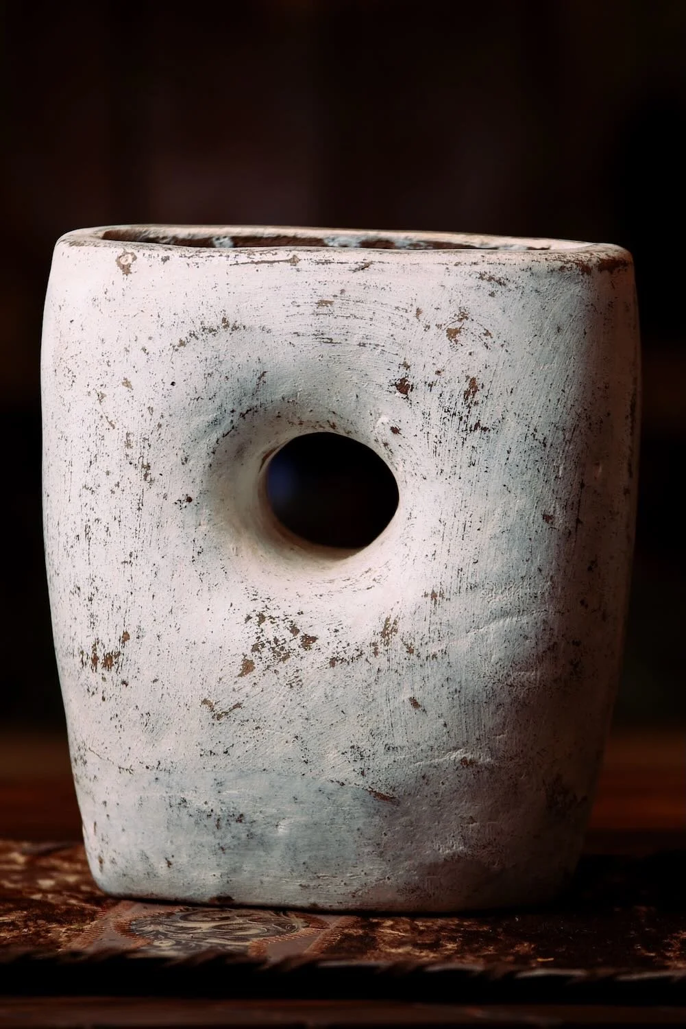White Vase with Hole. Hand-sculpted Mexican clay vase with a unique hole-through-center design and distressed white finish.
