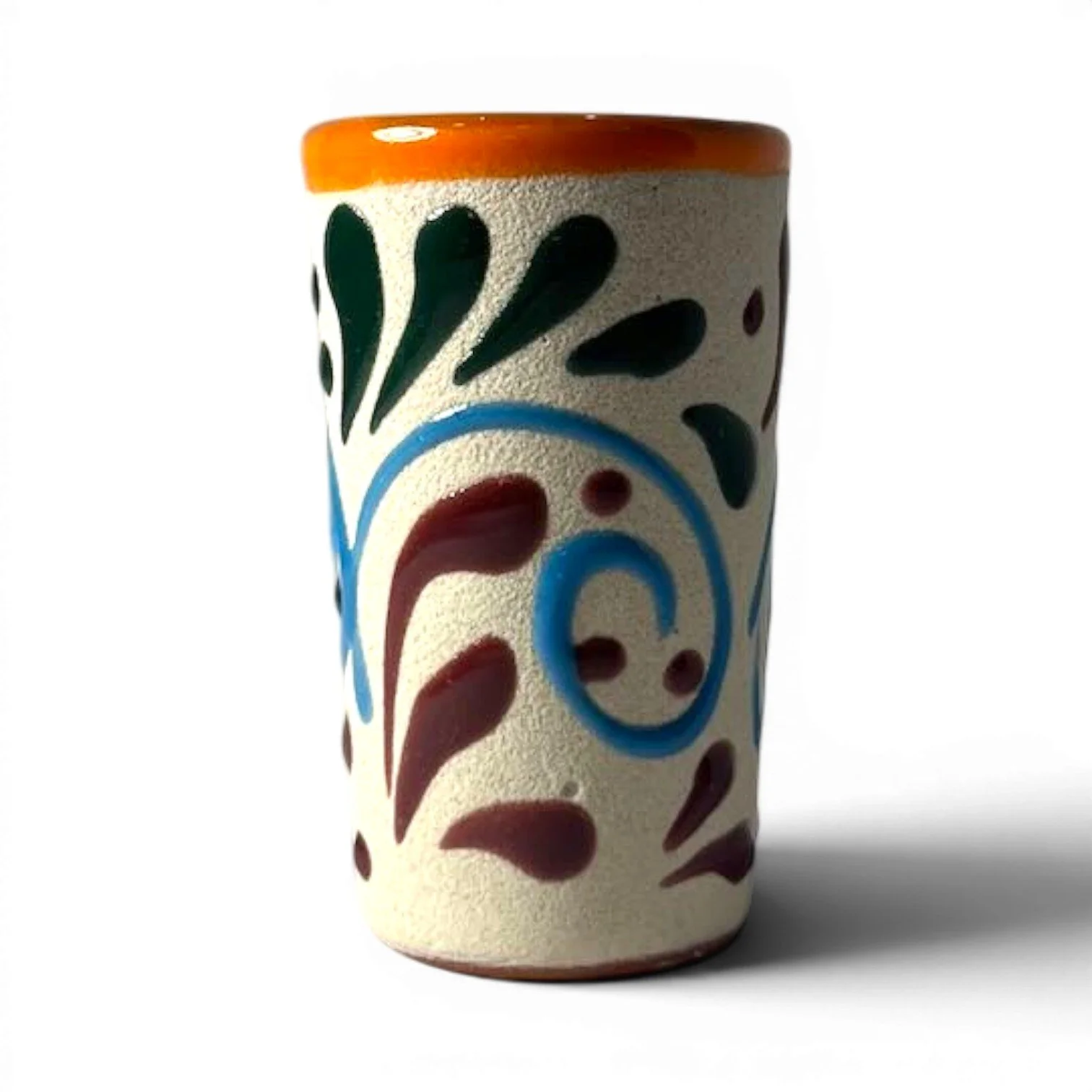 Handmade Mexican stone tequila shot cups with vibrant Talavera design and glazed interior.