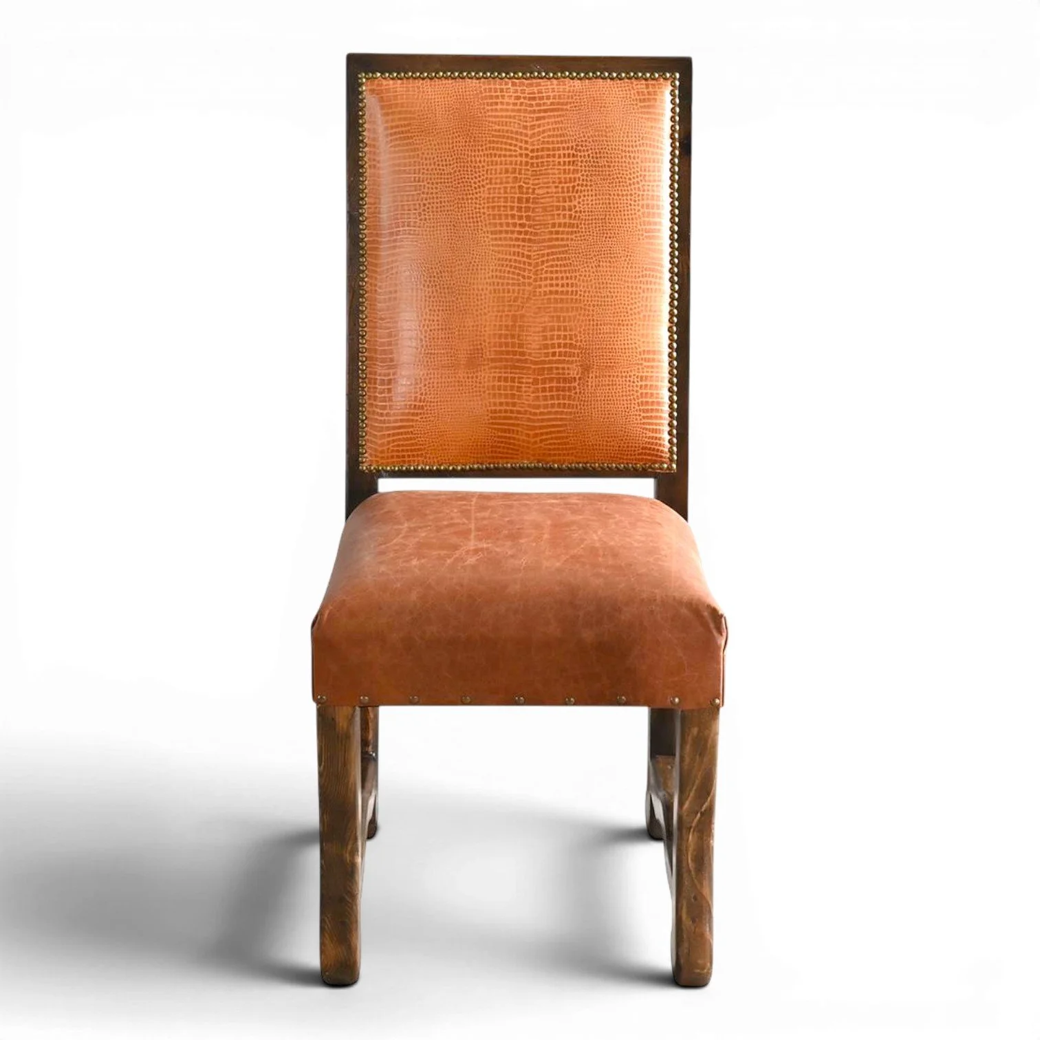 Handmade San Lucas terracotta leather dining chair with embossed leather back, nailhead trim, and dark wood frame crafted in Mexico.