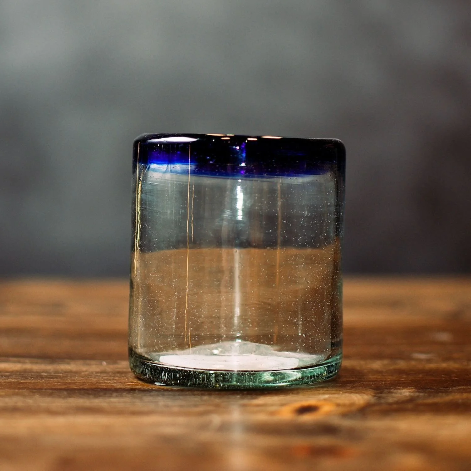 Handmade Mexican Cantina short glass with traditional cobalt blue rim and handblown artisan craftsmanship.