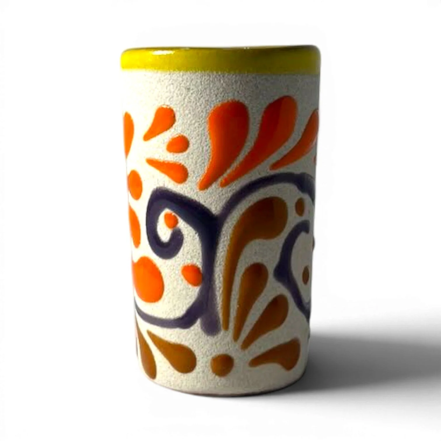 Handmade Mexican stone tequila shot cups with vibrant Talavera design and glazed interior.