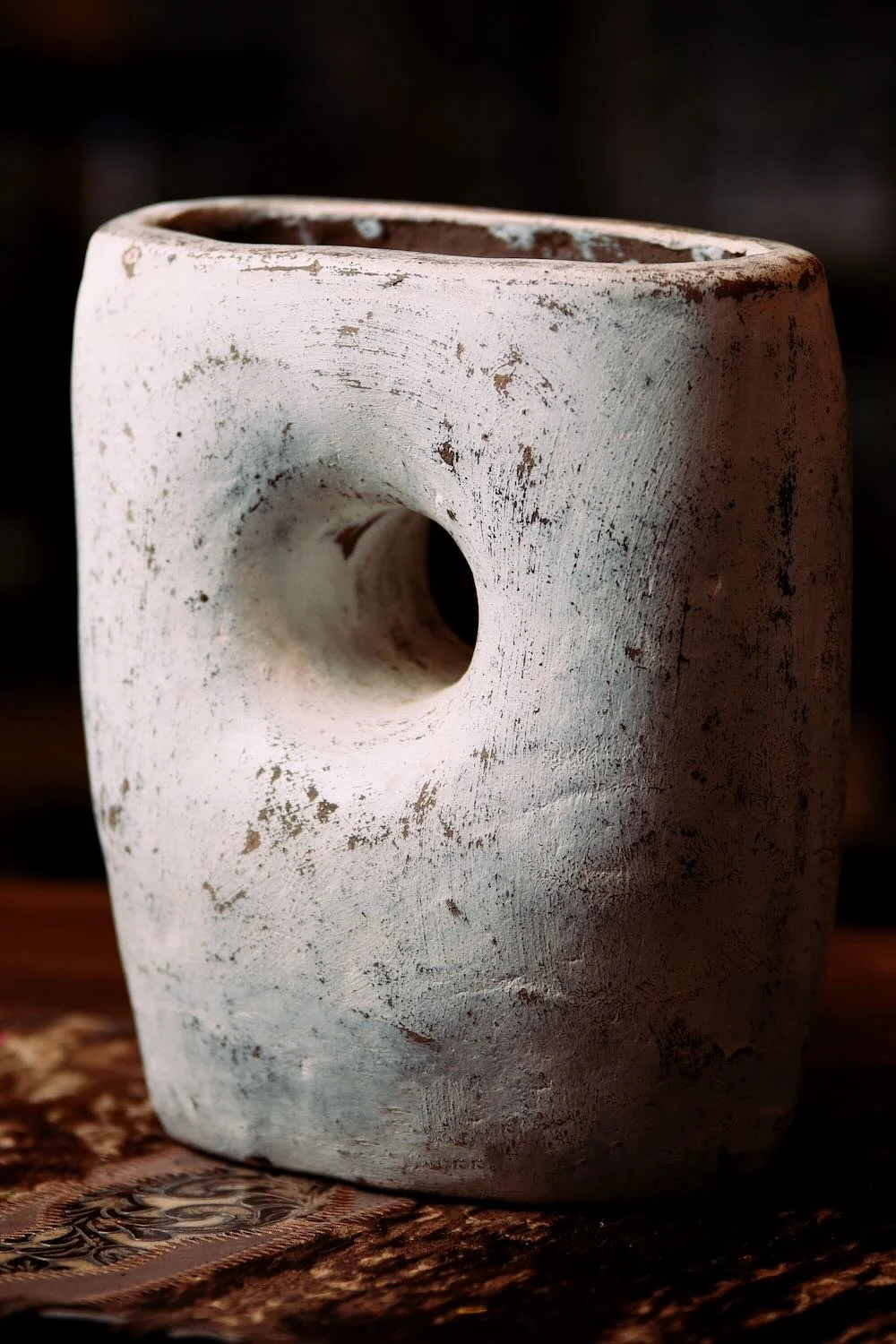 White Vase with Hole. Hand-sculpted Mexican clay vase with a unique hole-through-center design and distressed white finish.